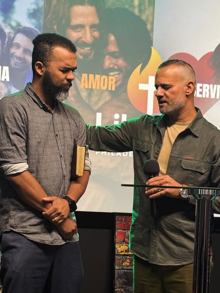 Pastor Roger orando por um membro da igreja ao final do culto